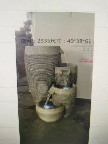 Stacked stone water feature with tiered bowls and flowing water for garden or patio