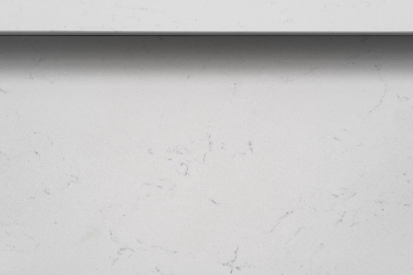 Closeup of white quartz tabletop with subtle grey veining detail