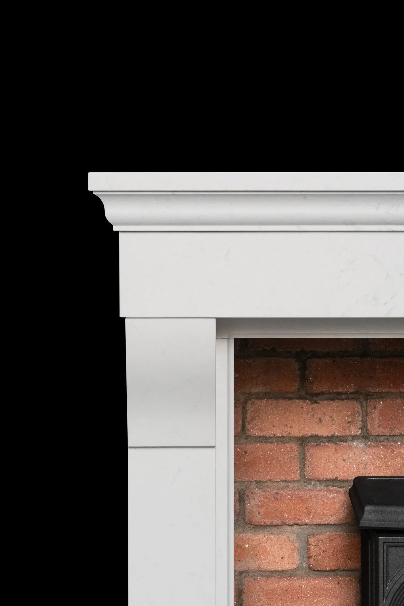 White fireplace mantel with brick interior and classic molding detail