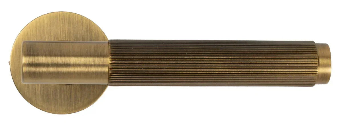 Brass door handle with brushed finish and vertical ribbed grip, side view