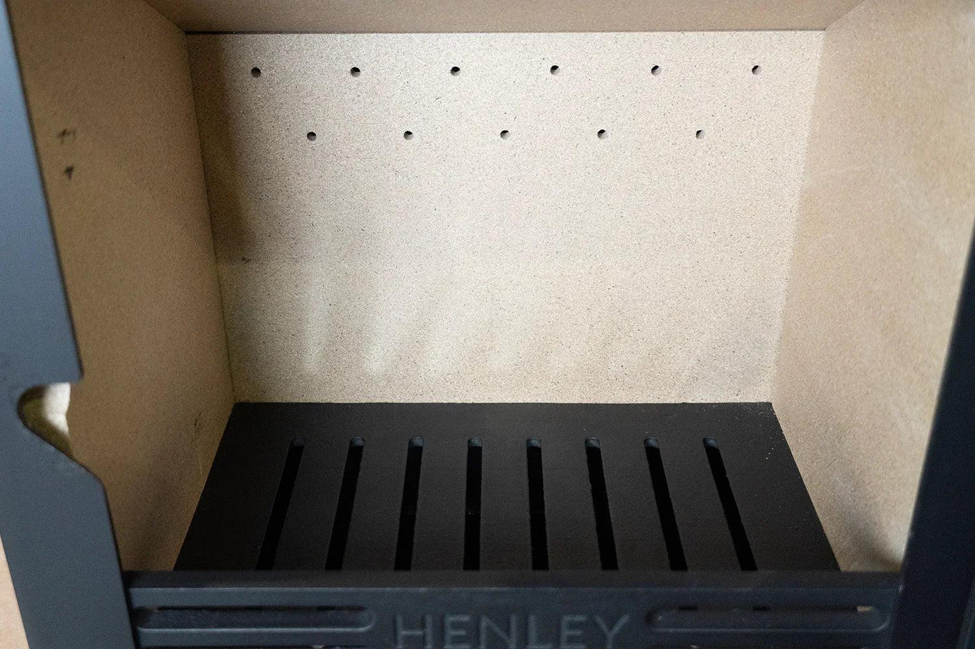 Inside view of stove firebox with heat-resistant brick lining and black metal grate