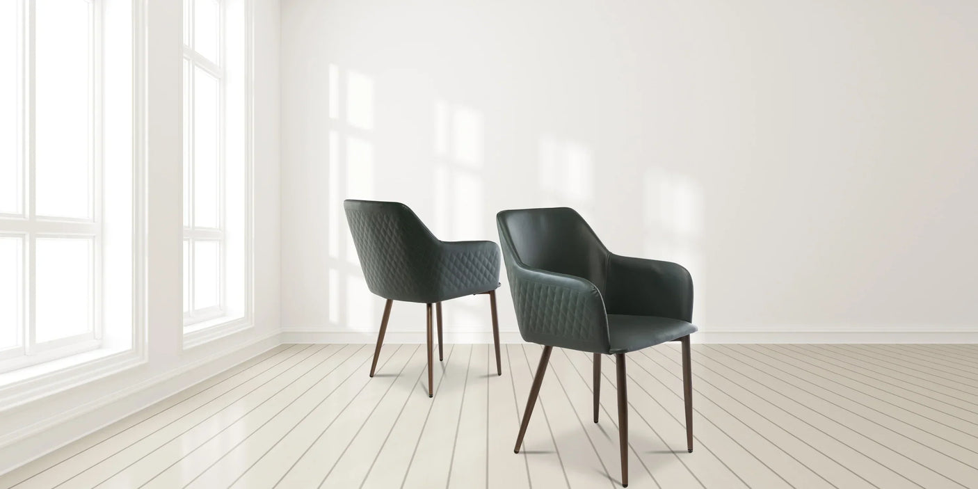 Set of two dark green upholstered dining chairs with quilted backs in a bright modern room