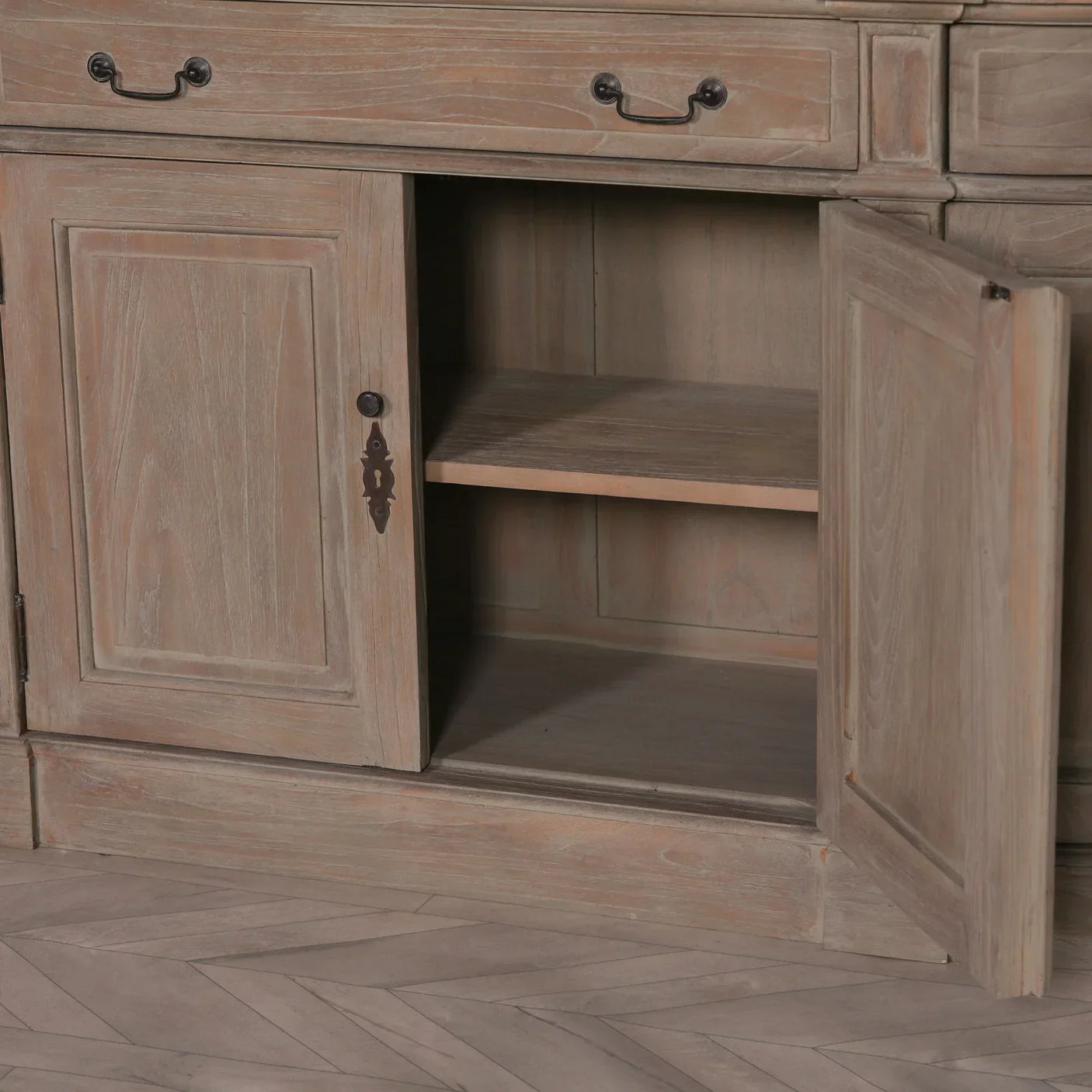 Light wood sideboard with open cabinet door showing interior shelf and drawer handles