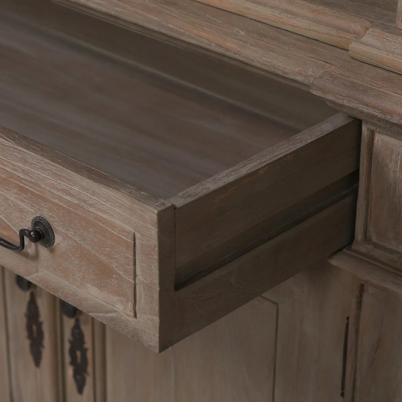 Natural wood sideboard drawer with black metal handle, close-up on texture and joinery
