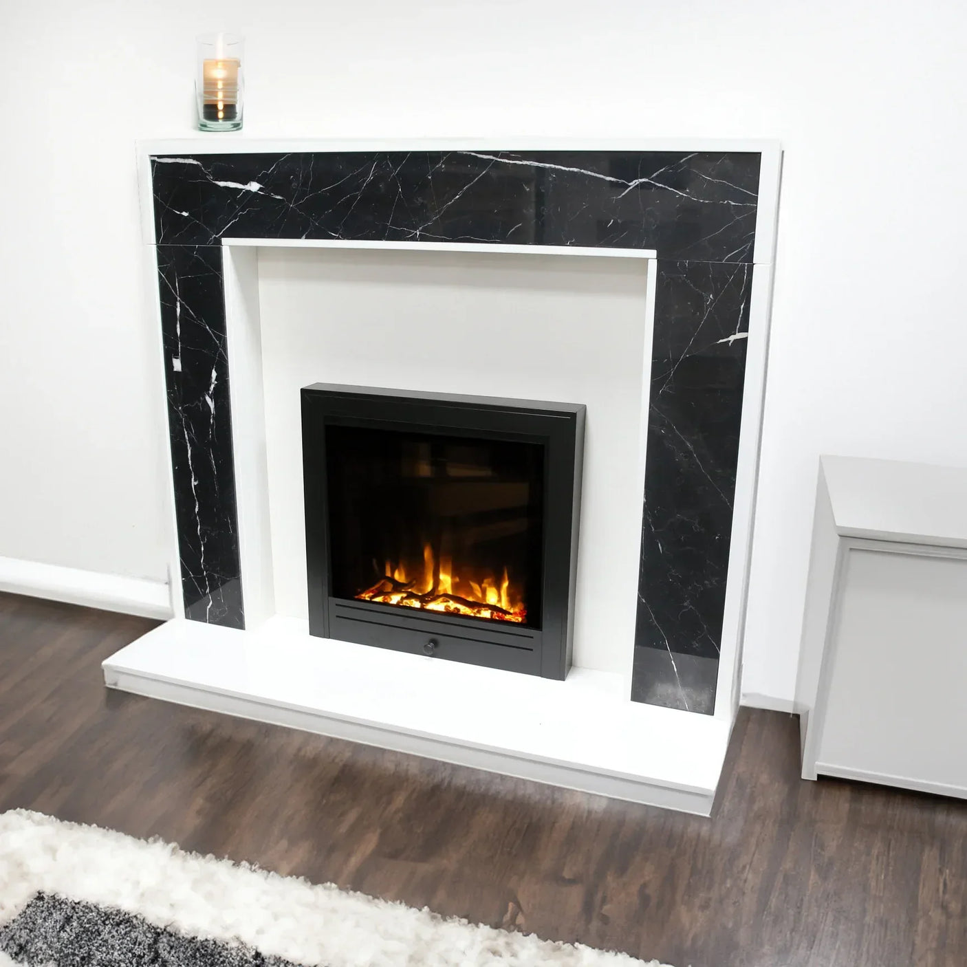 Modern electric fireplace with black marble surround on wood flooring