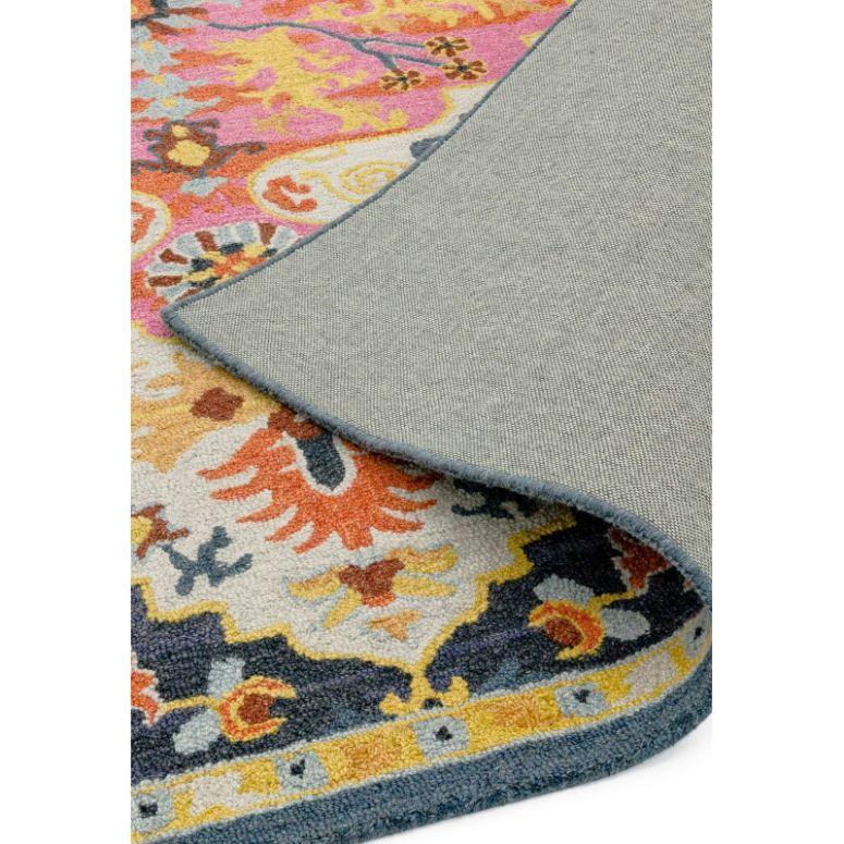 Colorful patterned rug with floral motifs, showing detailed corner and textured backing