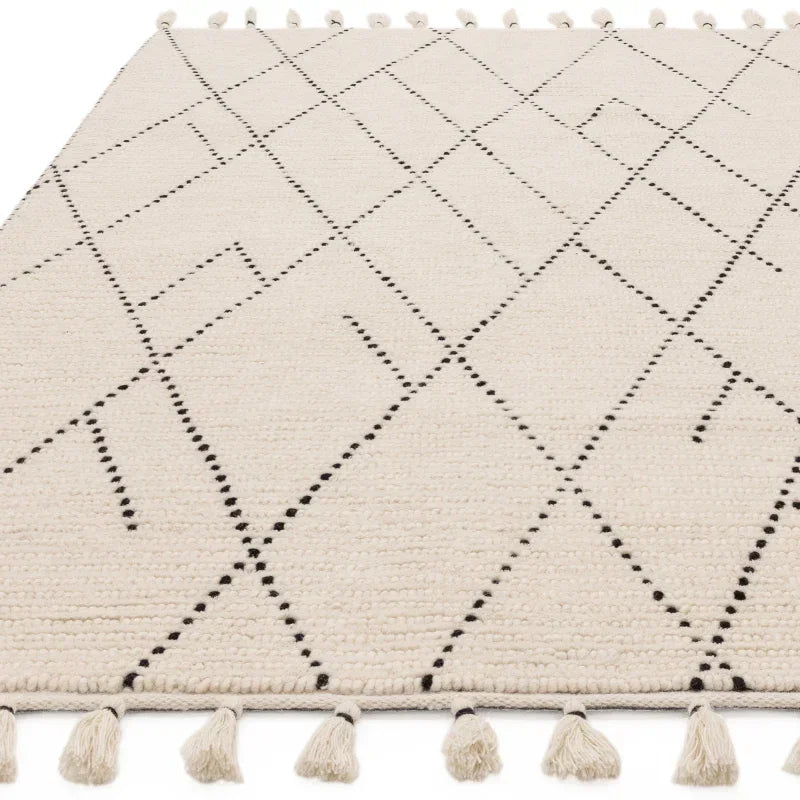 cream wool rug with black geometric pattern and tassel edges