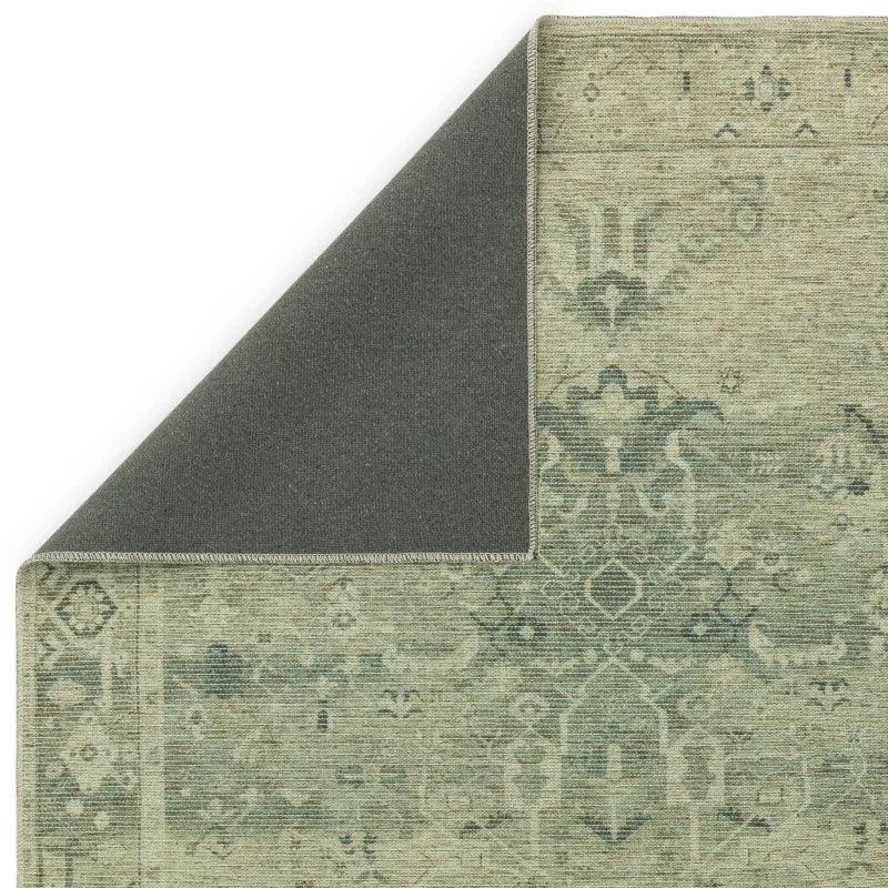 Green patterned rug with visible corner showing non-slip backing