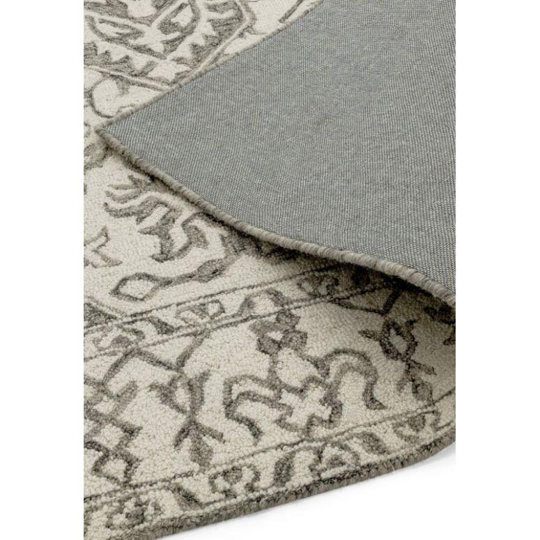 Neutral patterned rug with woven grey backing, corner folded to show texture and detail