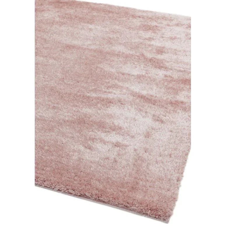 Soft pink shaggy area rug with thick pile, close-up of corner and texture