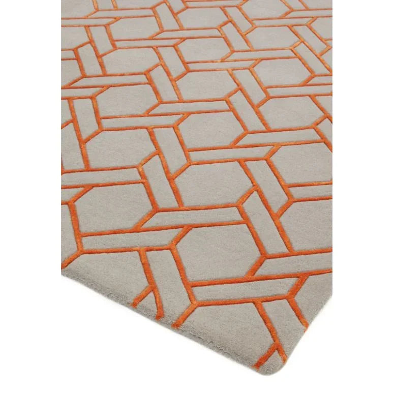 Geometric pattern rug with orange lines on a light beige background, corner view