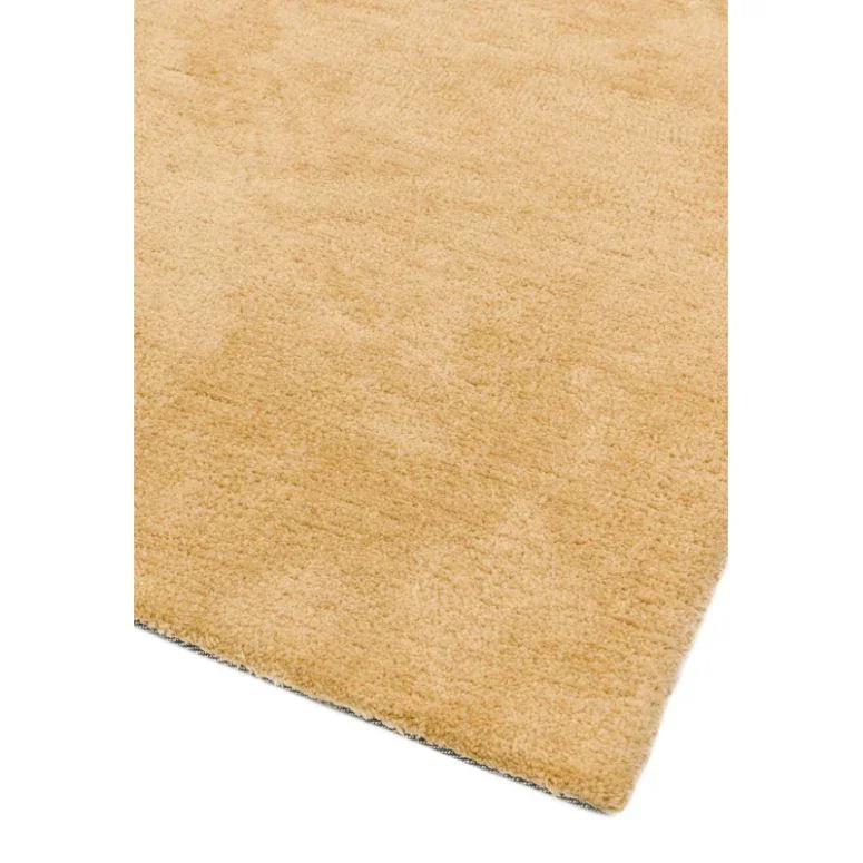 Beige area rug with soft texture and straight edge, close-up corner view