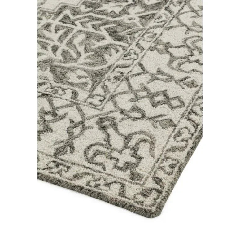 Grey patterned area rug with textured border and geometric design on light background