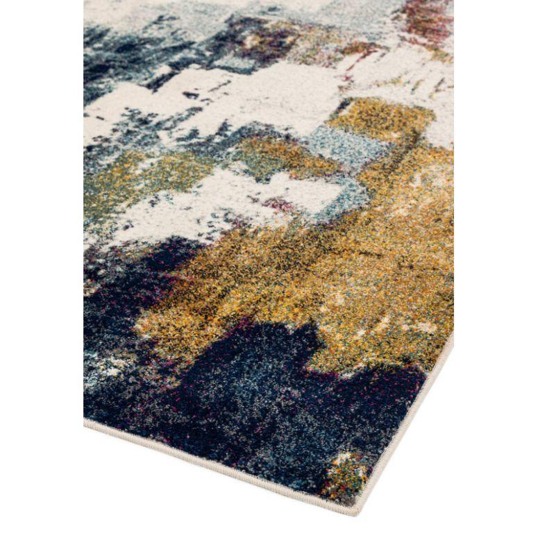 Modern abstract rug with blue, gold, and cream pattern, close-up of corner and texture