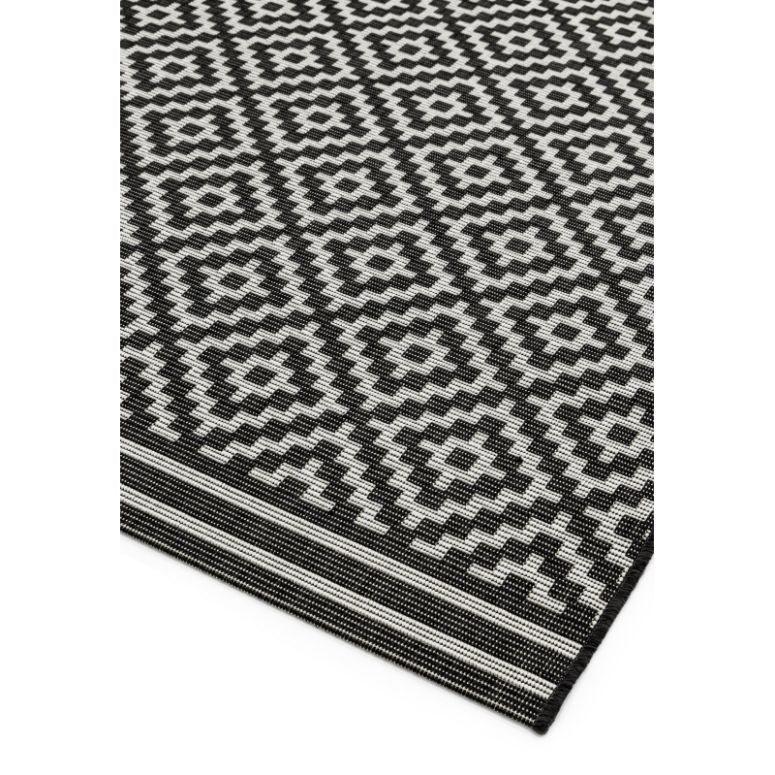 Black and white geometric pattern rug with diamond design, close-up of woven texture