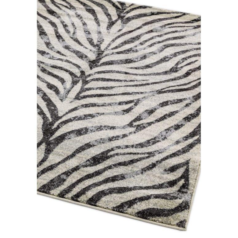Grey and white zebra pattern area rug with soft texture, shown from a corner angle