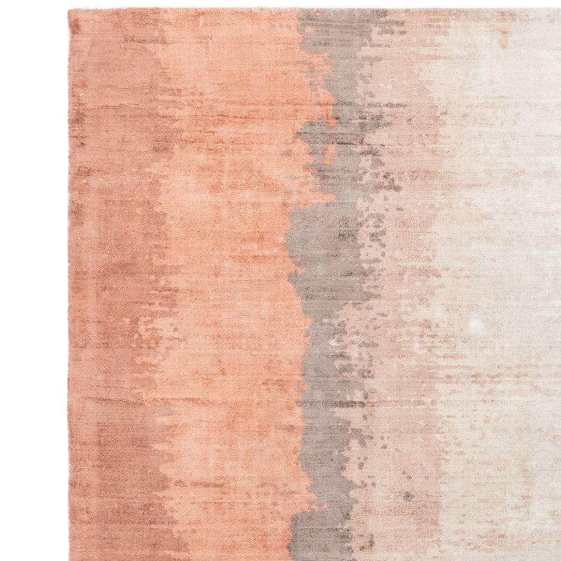 Rectangular area rug with peach, beige, and grey gradient pattern, close-up of texture