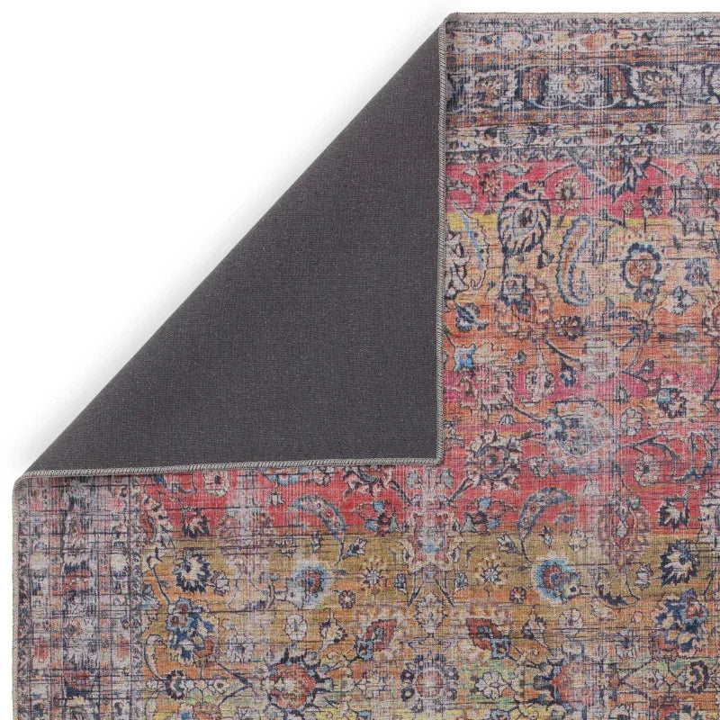 Multicolour vintage style area rug with floral pattern and corner folded to show backing
