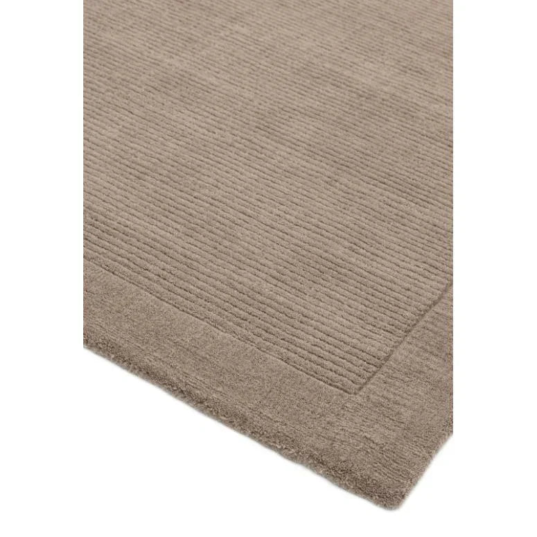 Beige textured rug with subtle striped border corner detail