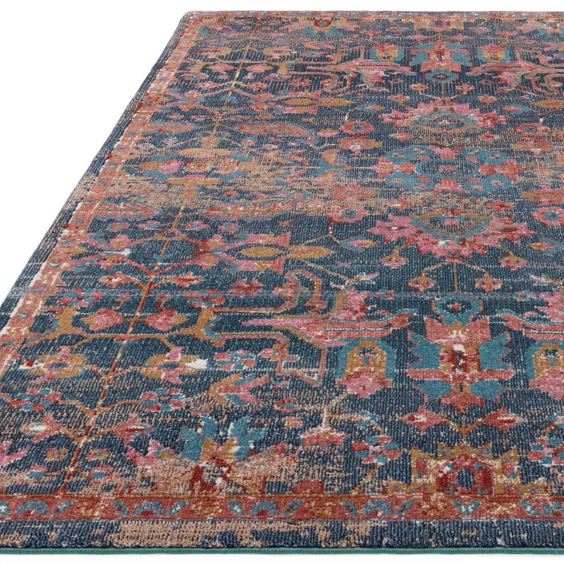 Multicolor patterned area rug with blue, pink, and gold floral motifs and detailed border