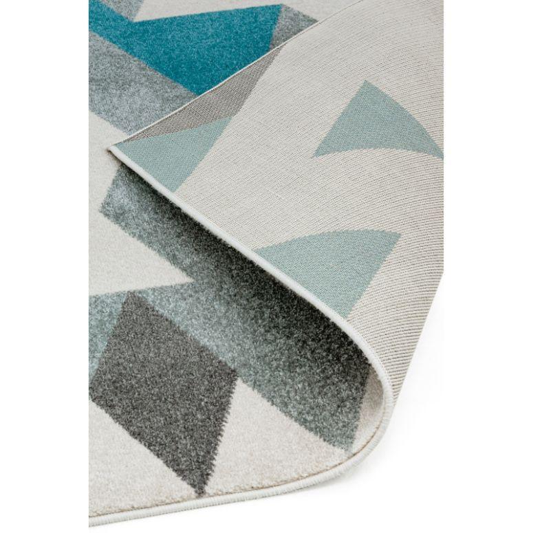 Modern geometric rug with blue and grey triangles, close-up of corner and texture