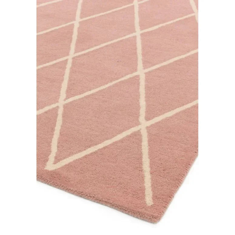 Pink area rug with cream crisscross pattern and soft texture, close-up corner view