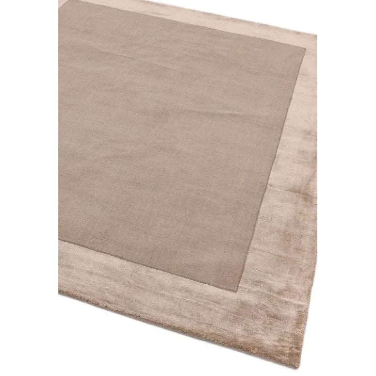 Beige border area rug with soft texture and rectangular design, close-up angle