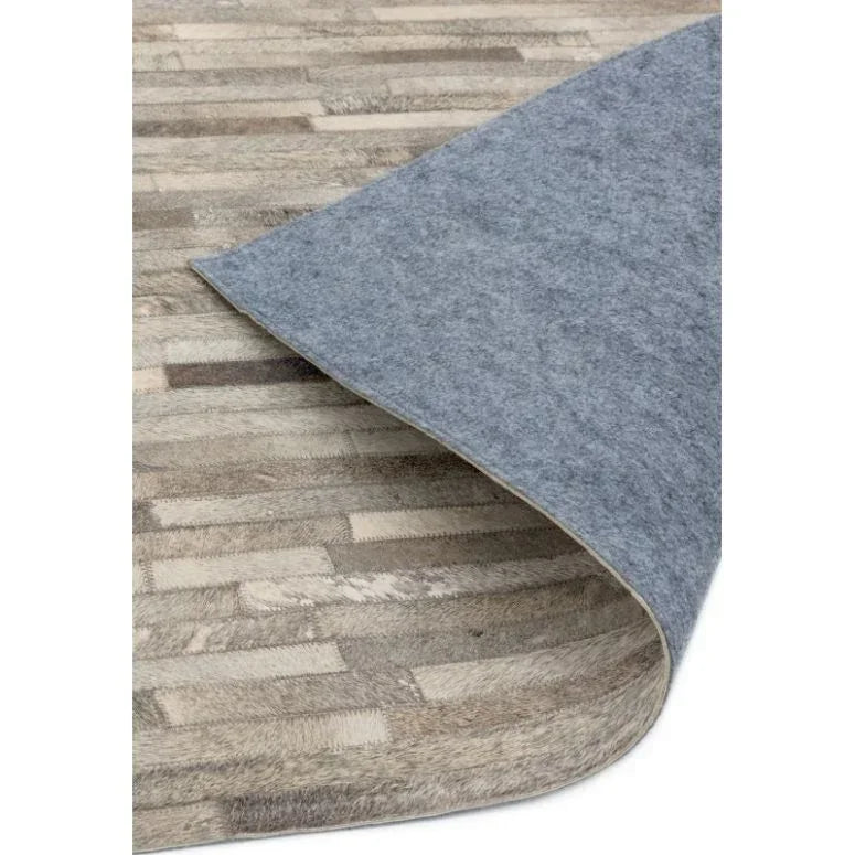 Beige patchwork rug with fabric backing corner folded to show non-slip underside