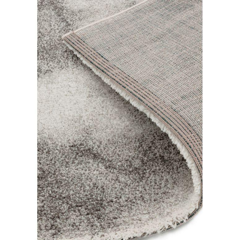 Grey area rug with soft textured pile and corner showing woven backing detail