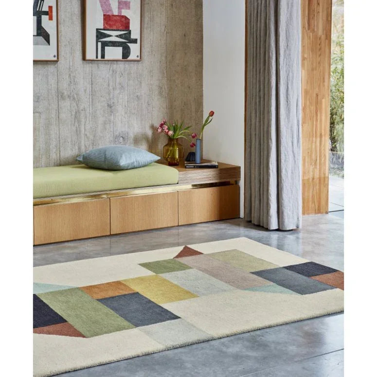 Modern geometric wool rug in neutral living room with concrete floor and wooden bench seating