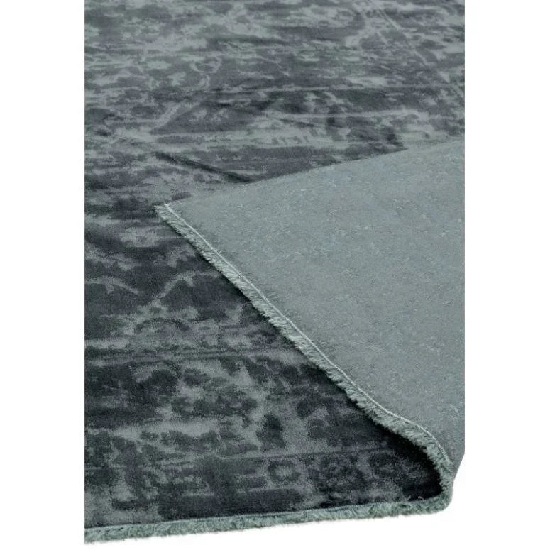 Grey patterned rug with vintage effect and visible corner flipped to show backing