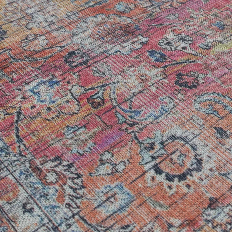 Vintage style floral pattern rug with red, orange, and blue woven details, close-up view