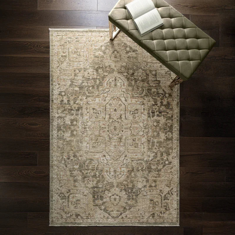 Vintage patterned area rug on dark wood floor with green tufted bench and open book