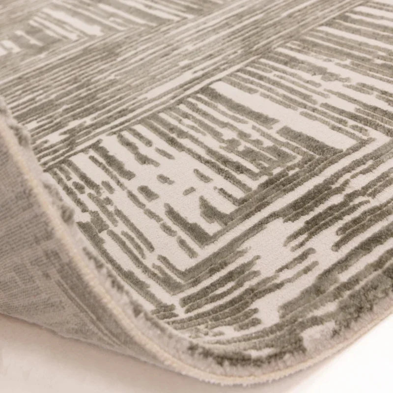 Close-up of modern patterned rug with raised geometric design in grey and cream tones