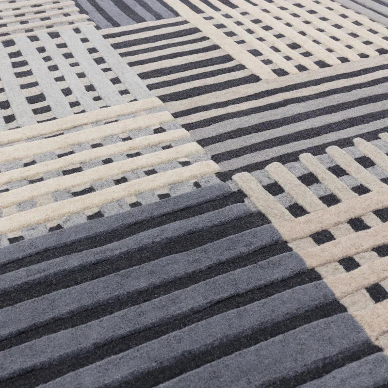 Modern wool rug with grey, cream and black geometric stripe pattern close-up