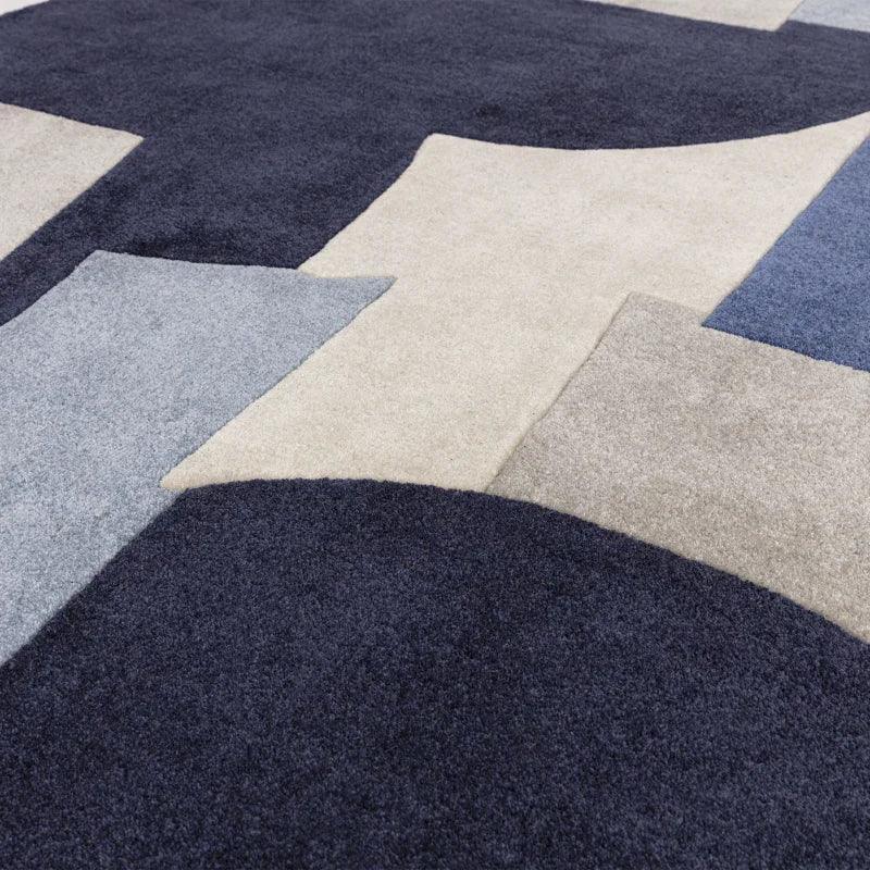 modern wool rug with geometric navy, grey, and cream pattern close-up view