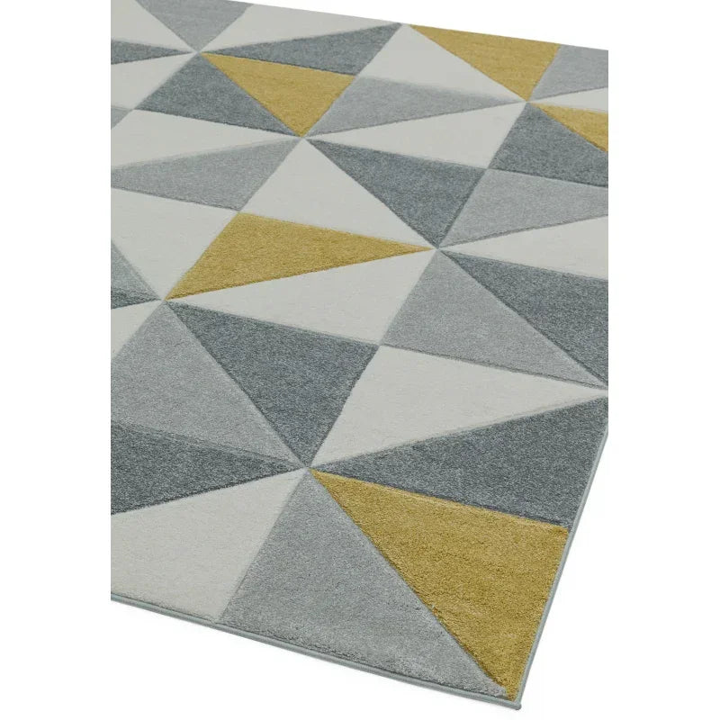 Geometric patterned rug with grey, yellow, and white triangular shapes