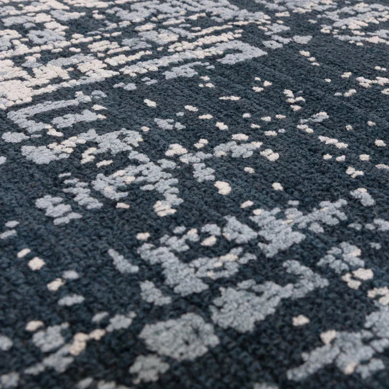 Close-up of textured patterned rug in dark blue and light grey tones