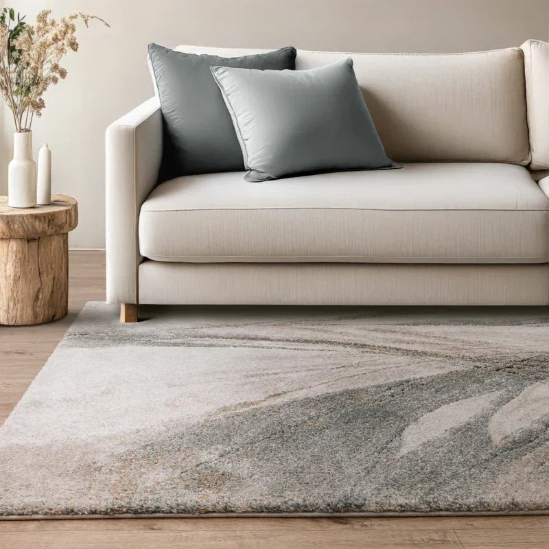 Beige fabric sofa with blue cushions, wooden side table, and modern grey area rug