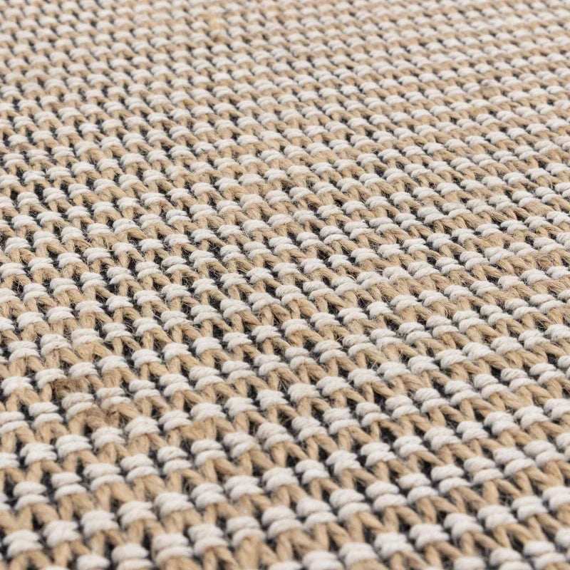 Closeup of woven jute rug texture in natural beige and cream tones