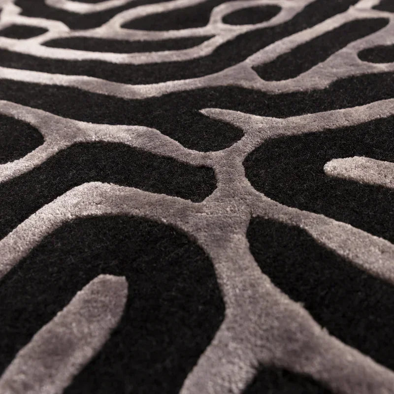 Close up of black and grey patterned rug with textured abstract design