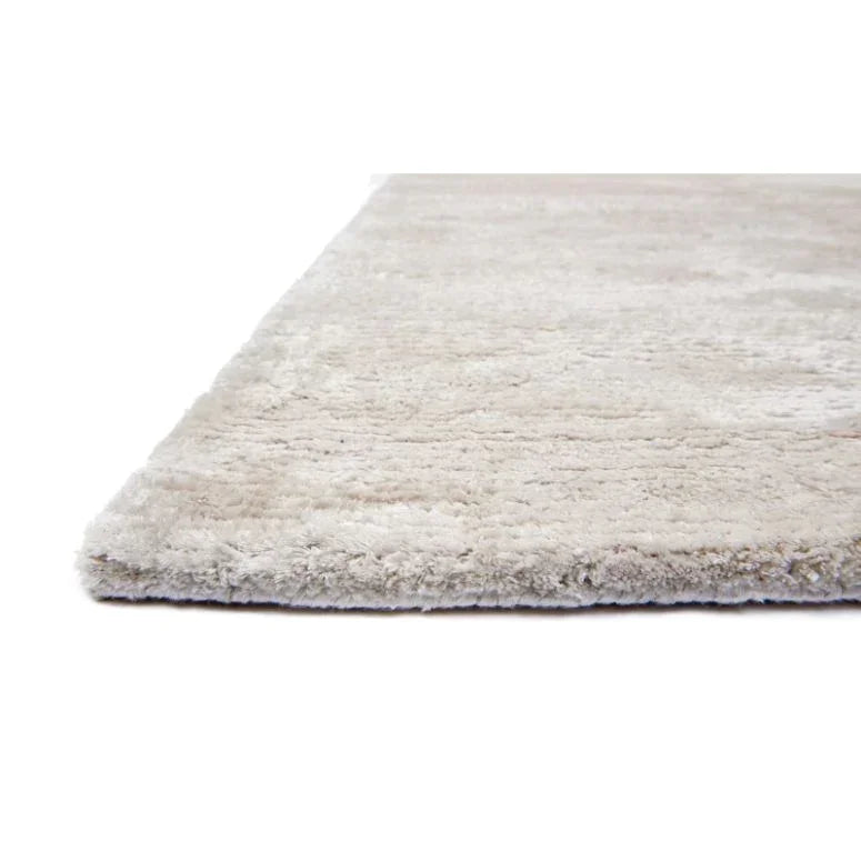Close view of beige shaggy rug with soft pile and textured surface