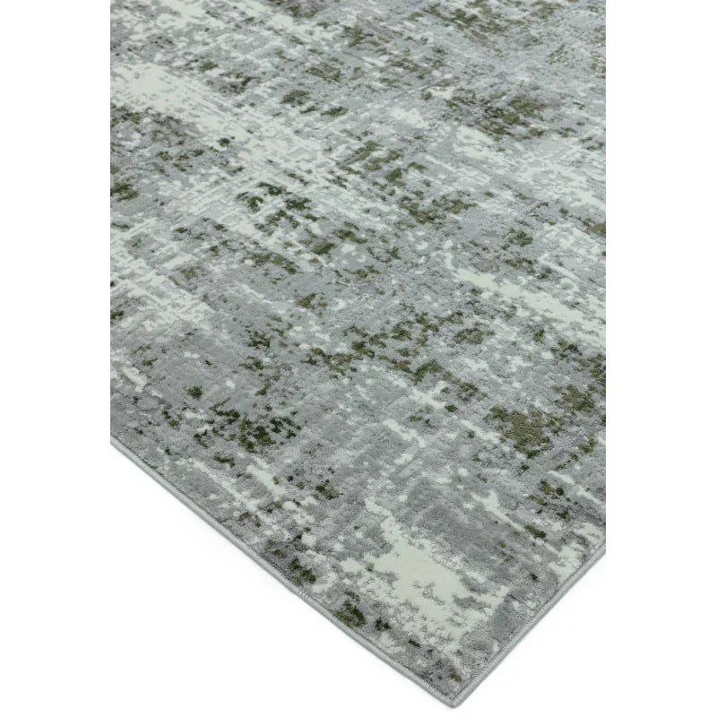 Modern grey area rug with abstract green and cream pattern, close corner angle view