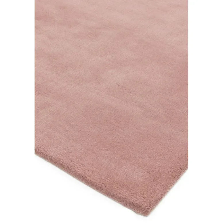 Blush pink area rug with soft texture shown from angled corner view