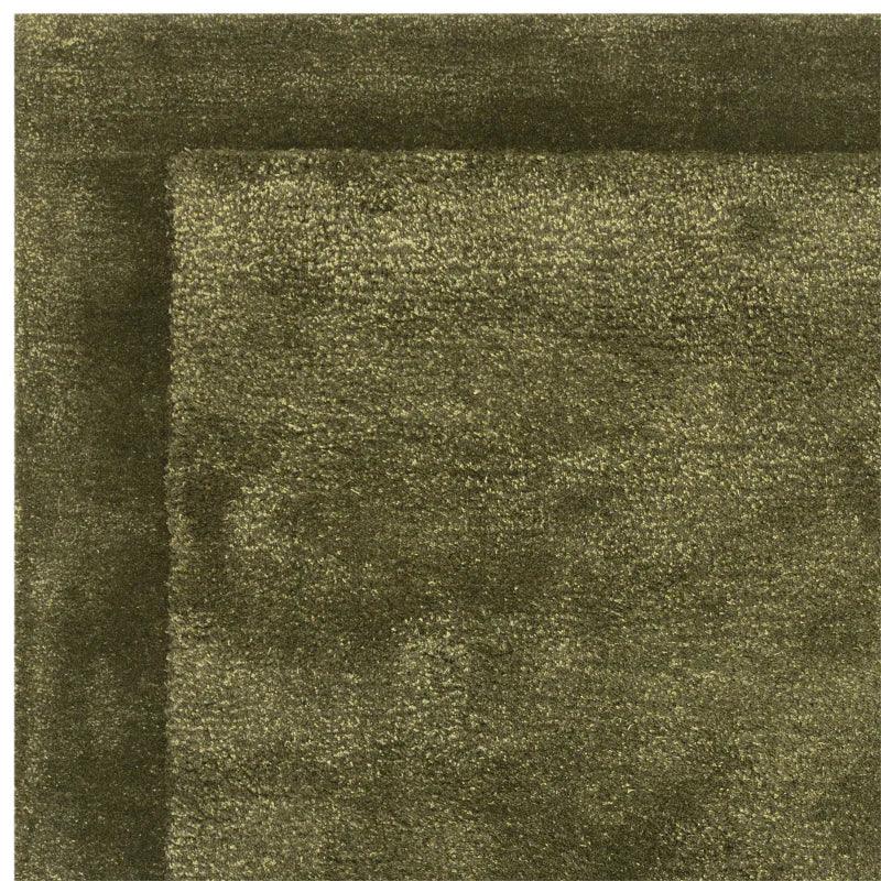 Green wool rug with subtle border pattern, close-up of textured pile and corner