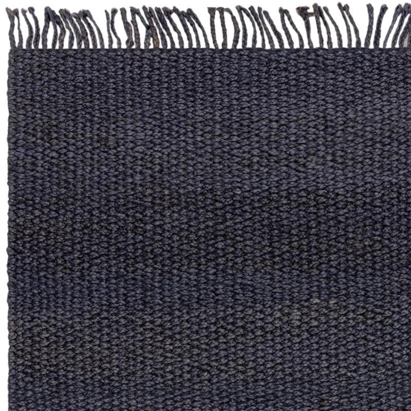 Dark woven wool rug with fringe edge and textured surface detail
