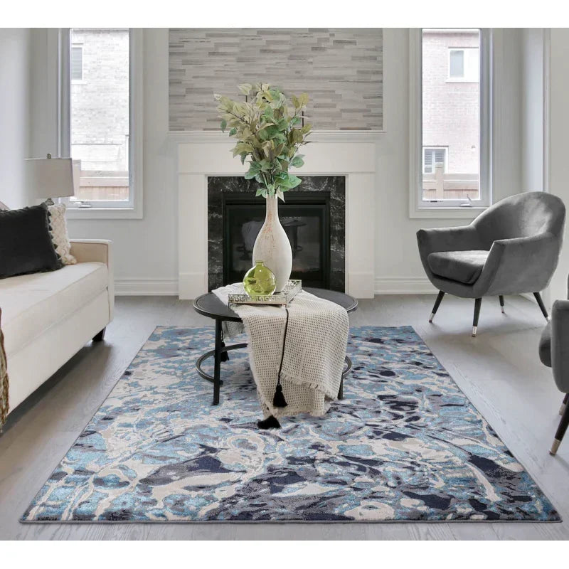 Blue abstract area rug in modern living room with grey chair and white sofa