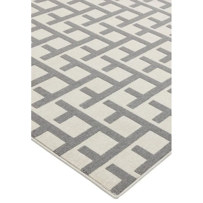 Geometric grey and cream rug with modern square pattern, close-up corner view
