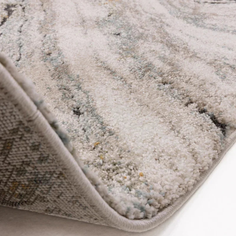 Close-up of modern area rug with plush pile and abstract beige and cream pattern