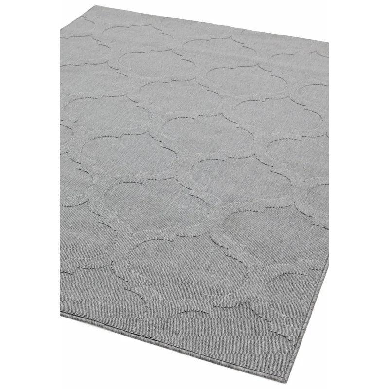 Light grey area rug with geometric pattern and textured fabric, angled corner view
